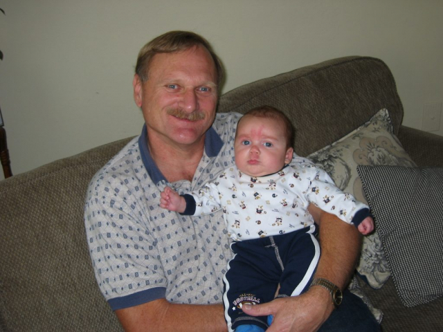 Proud Grandad holding his grandson Wade. A smile Laren, holding his infant grandson on a couch.