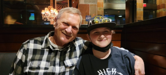 Laren sitting next to his granddaughter Rheanna. Medium shot of Laren and Rheanna at restaurant.
